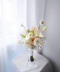 Side view of white calla lilies, peach gerberas and delicate garden flowers