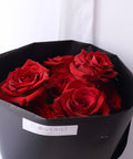 Close-up of red roses inside black bouquet wrapping