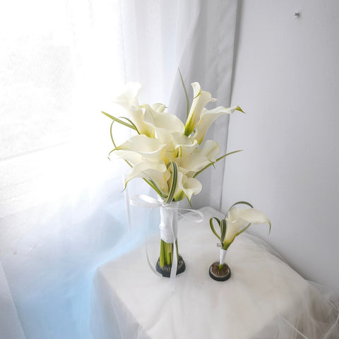 White calla lily bridal bouquet and matching boutonniere with looped grass and white ribbon